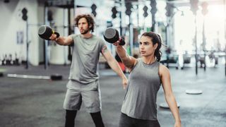 Two people performing a single-arm kettlebell swing