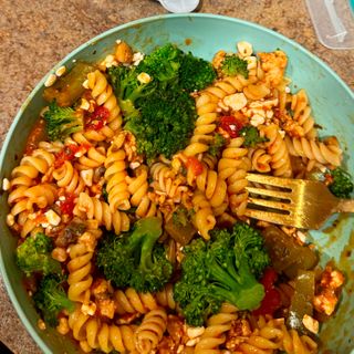 Bowl of tomato pasta with cottage cheese, broccoli and green pepper