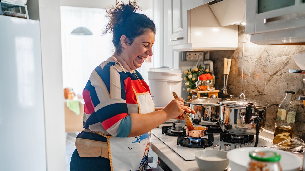 Smiling woman cooking in kitchen